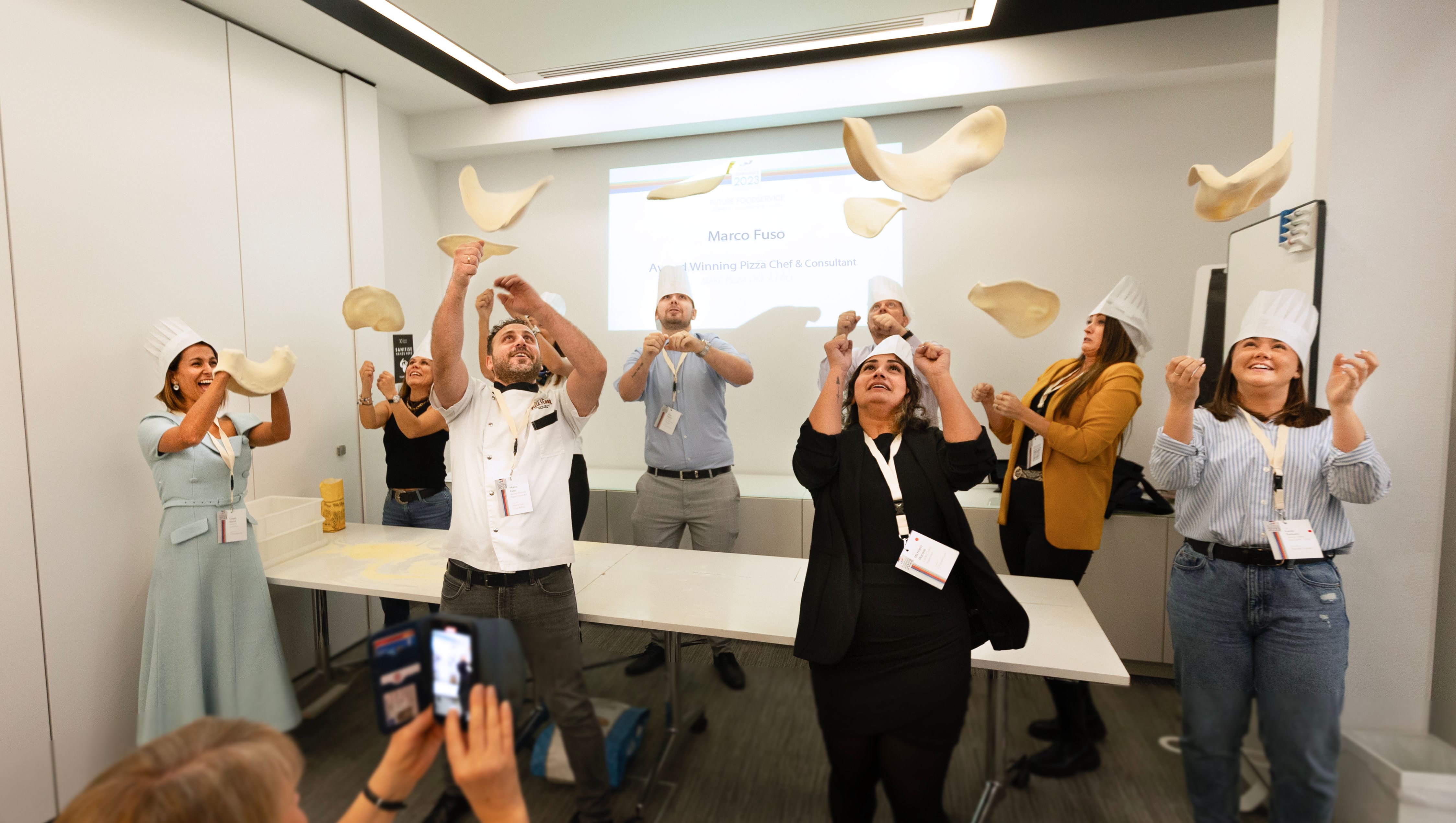 People spinning pizzas at the conference 